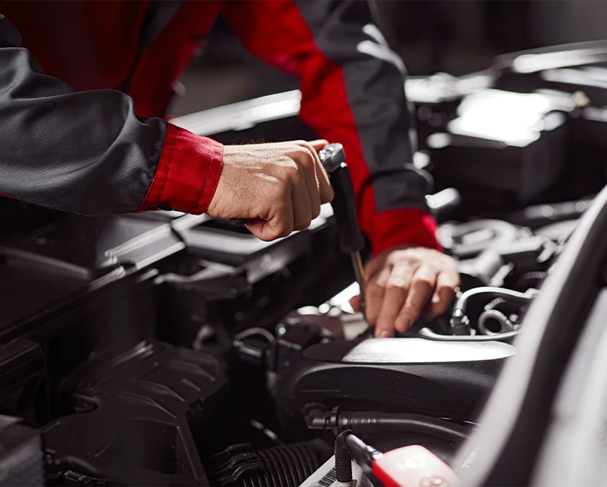 Mechaniker führt Reparaturarbeiten im Motorraum eines Autos durch